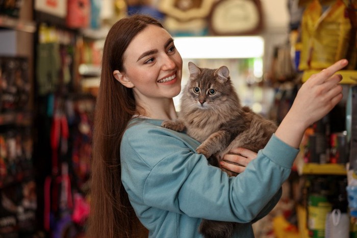 猫を抱いて買い物をする女性