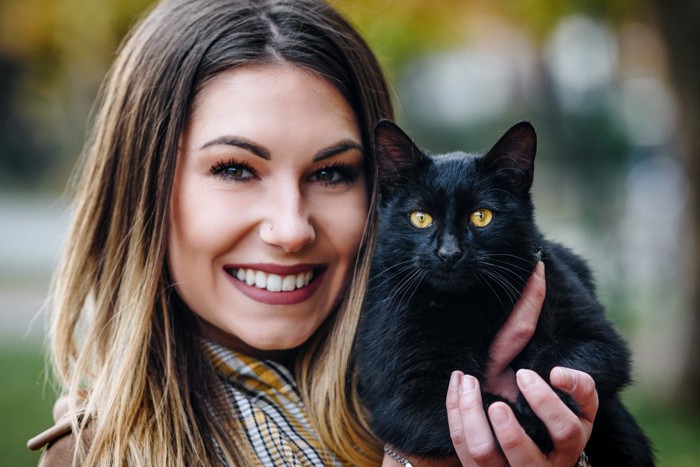 黒猫を抱く女性