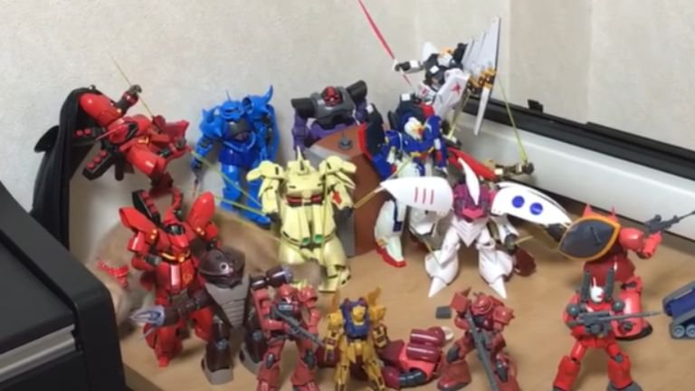 ガンプラが飾ってある棚を歩く猫