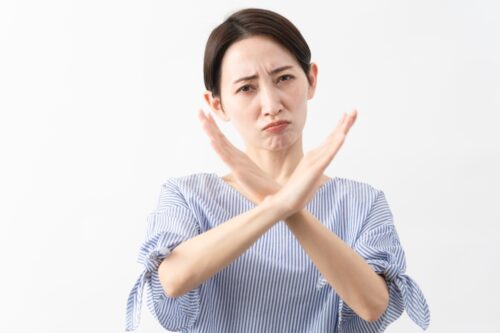 バツを示す女性