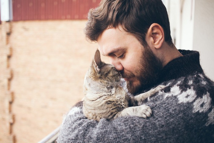 男性とキスをする猫