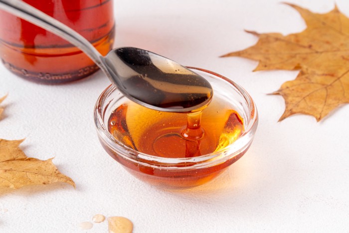 小皿に入ったメープルシロップをスプーンですくう様子