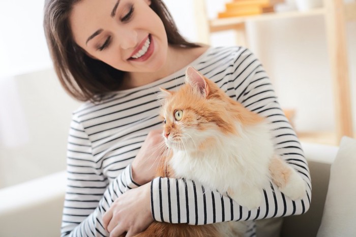 猫を抱っこしている笑顔の女性