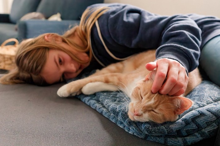 寝転がる猫と女性