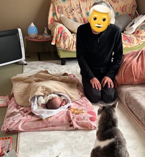 赤ちゃんを見守るじいじと猫