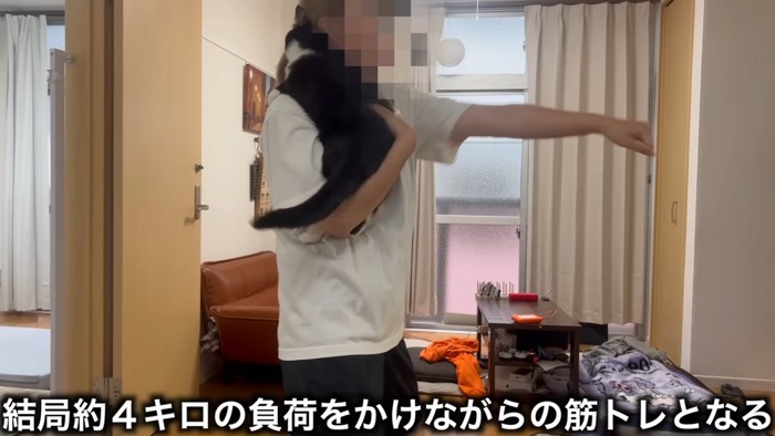 猫を抱っこして運動する人