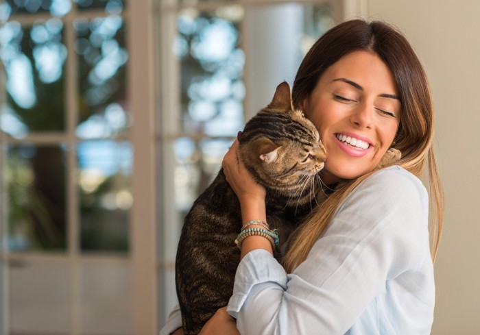 女性の顔にスリスリする猫