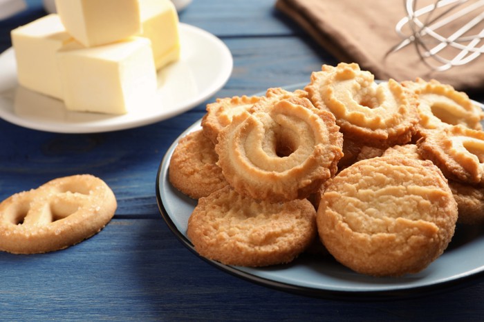 お皿に置かれたバターとバターを使って作られたクッキー