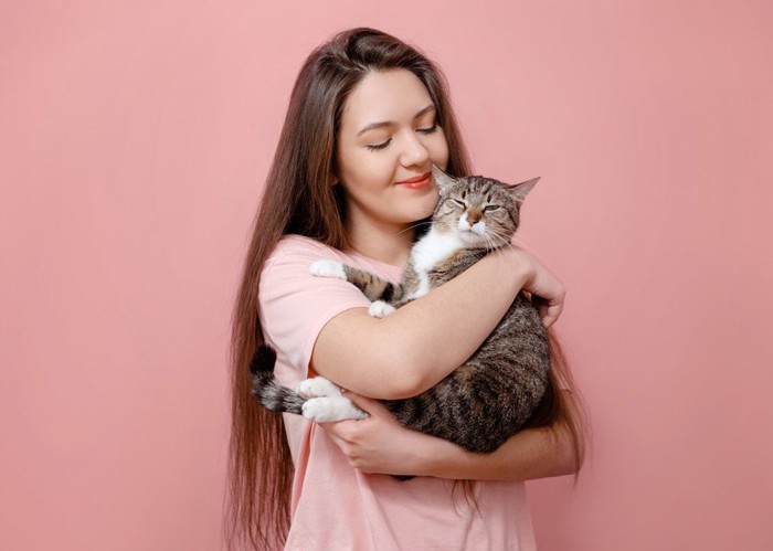 女性に抱っこされる猫