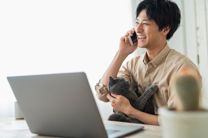 男性の会話中に抱かれている猫