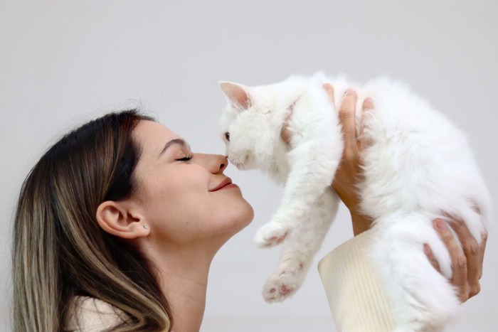 鼻キスをする女性と猫