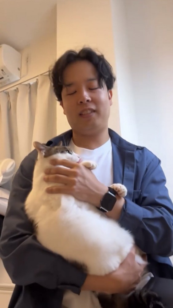 猫を抱っこする男性