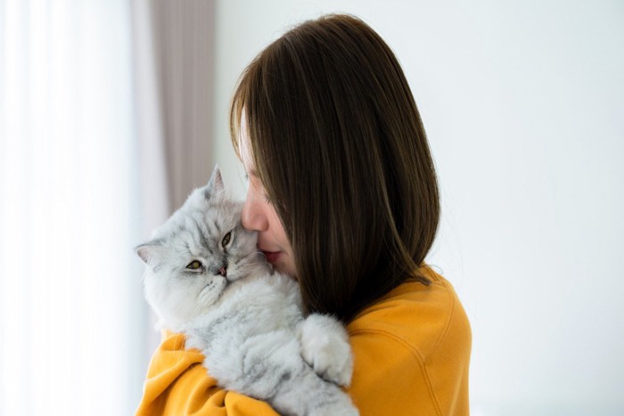 猫を抱きしめる人