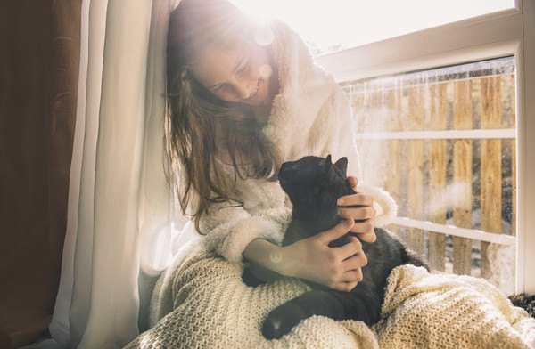 黒猫を抱っこする女性