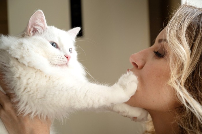 女性にキスされそうなのを嫌がる猫