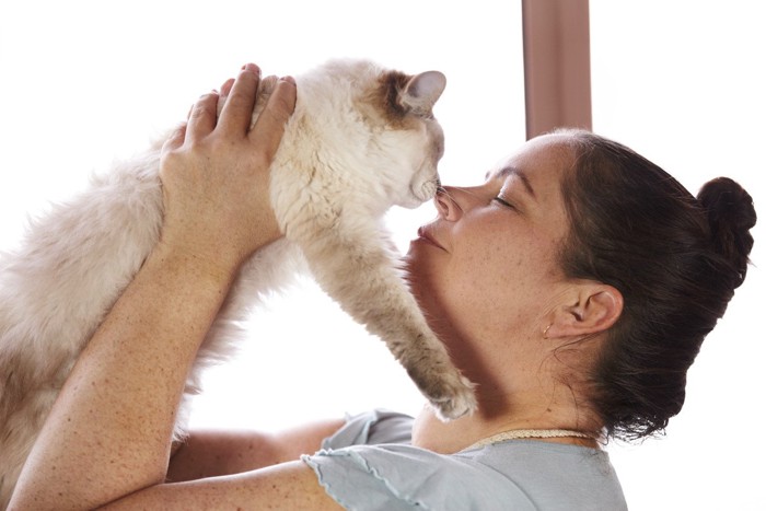 鼻チューをしている女性と猫