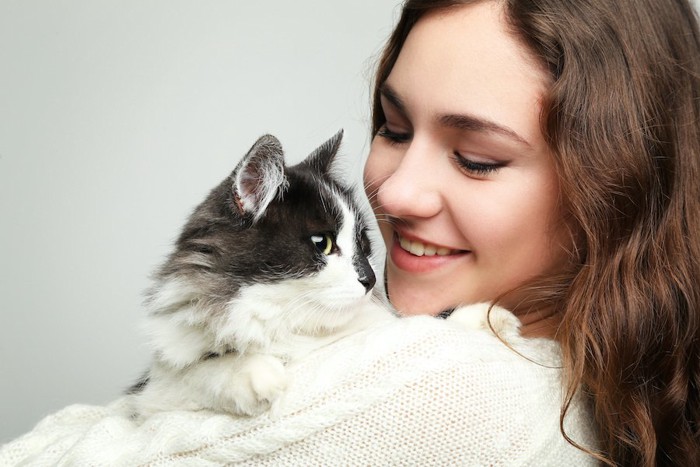 笑顔の女性に抱っこされている猫