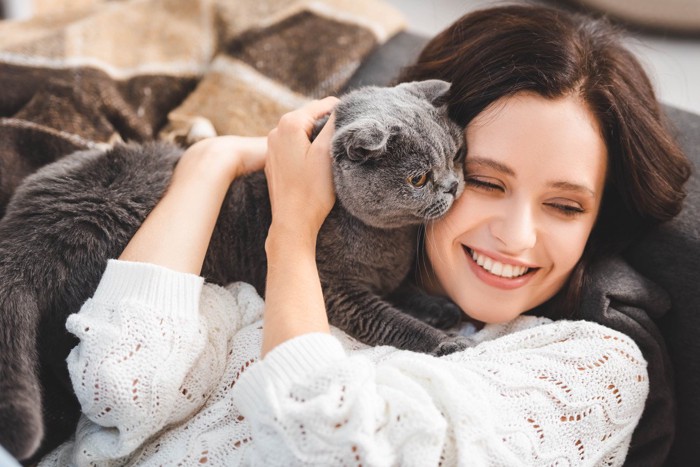 女性の顔にすりすりする猫