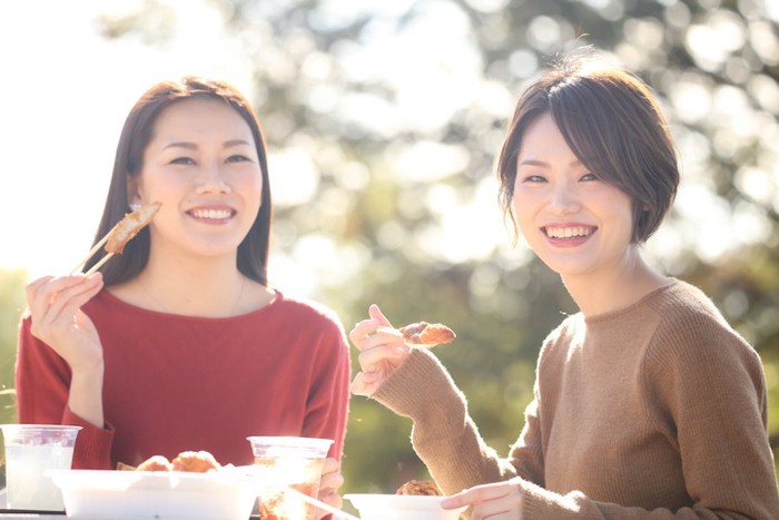 外で食事をする二人の女性