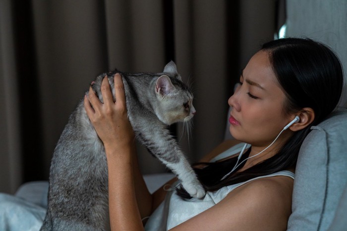 泣きながら猫を抱く女性