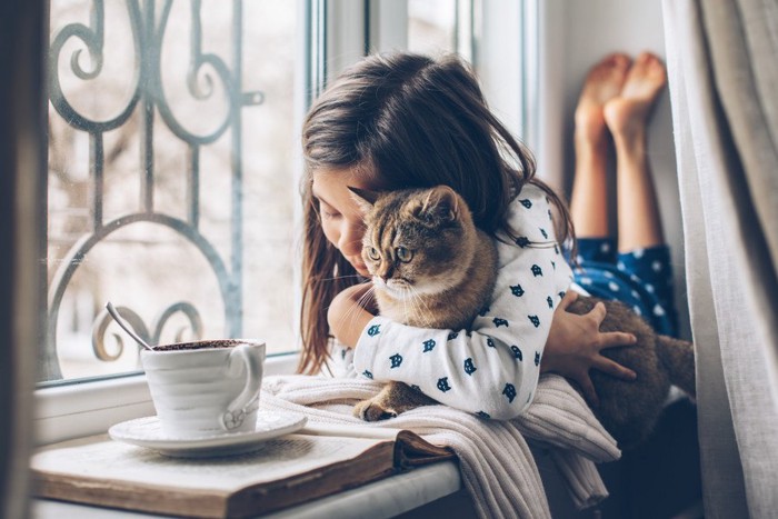 子供に抱かれる猫