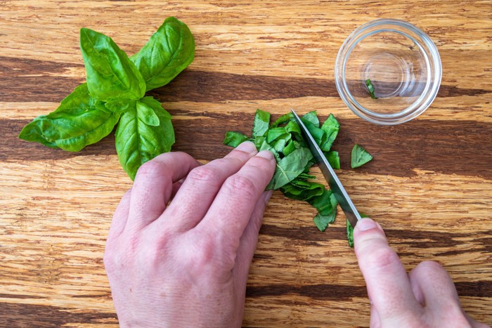 包丁でバジルを細かく切っている様子