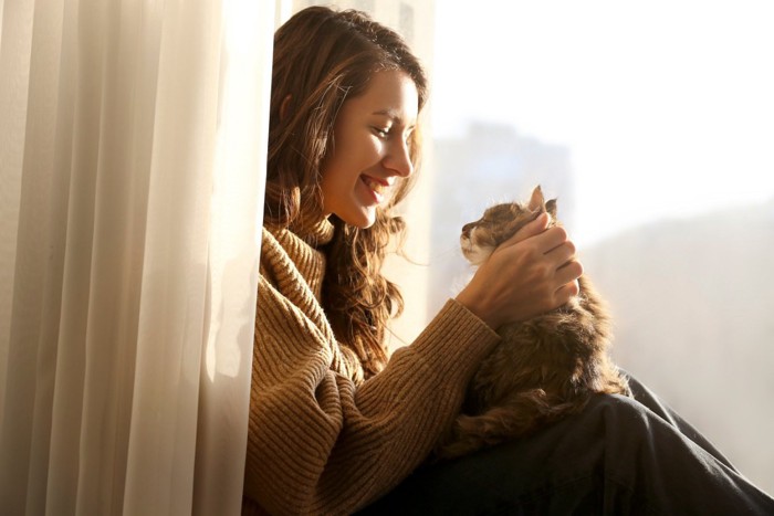 見つめ合う猫と女性