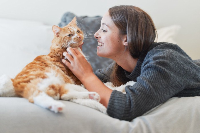 猫に話しかける笑顔の女性