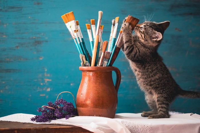 絵筆をいじる子猫