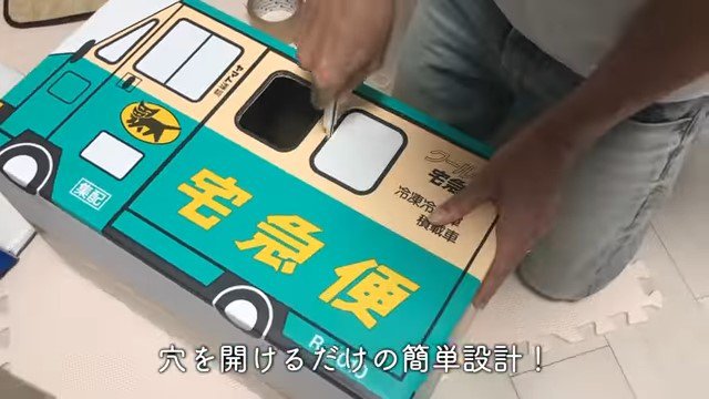 ダンボールに穴を空ける男性