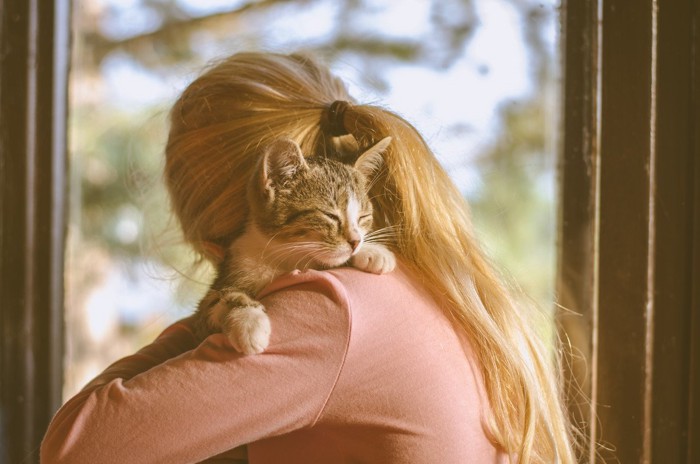 猫とハグをする女性