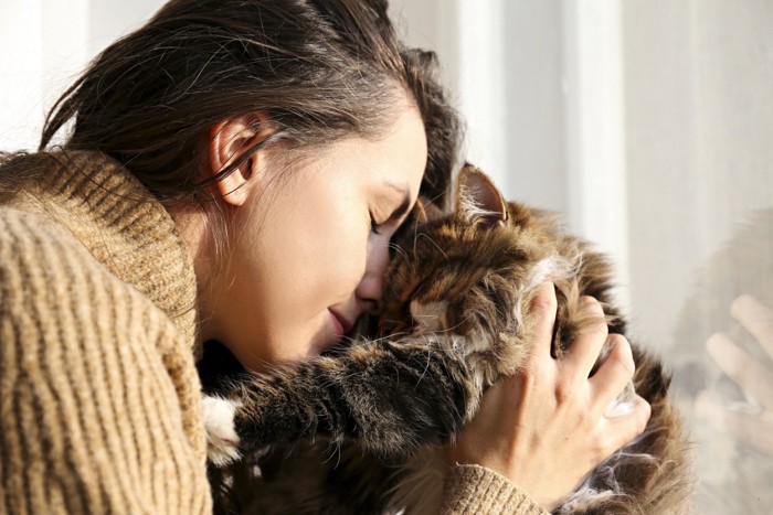 猫と額を寄せる人