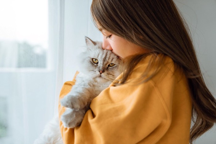 女性に抱かれる猫