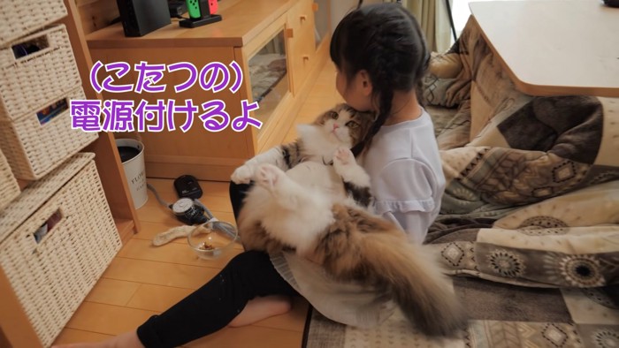 猫をだっこして座る子供