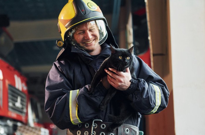 救助隊に抱かれる黒猫