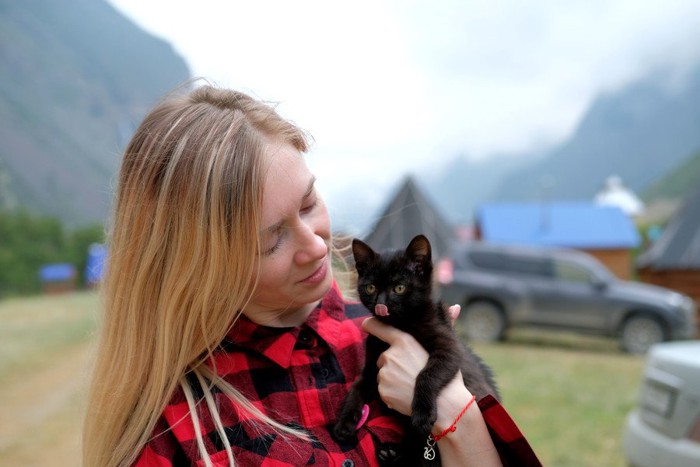女性に抱かれる黒猫