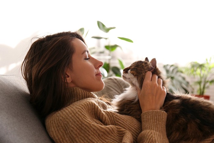 幸せそうな猫と見つめる女性