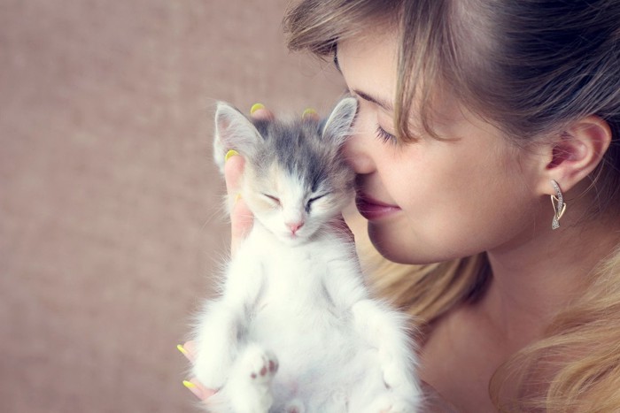 女性に抱かれて眠る子猫