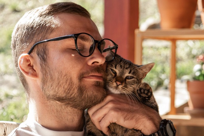 猫を抱っこする男性