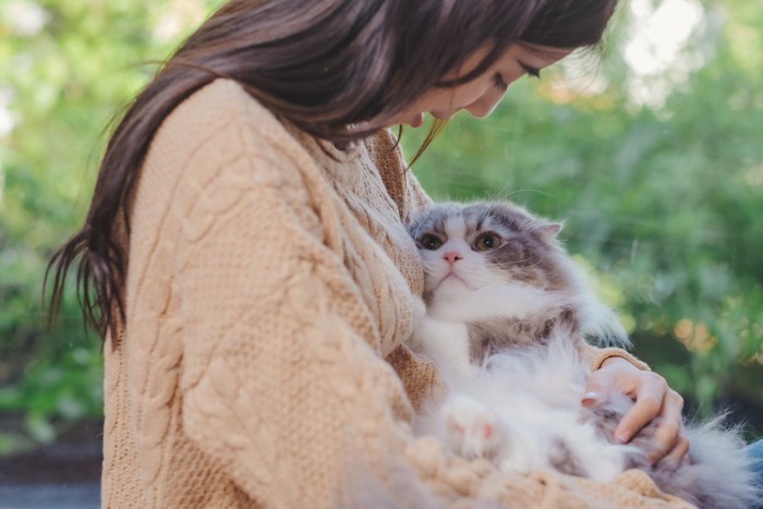 女性に抱かれる猫