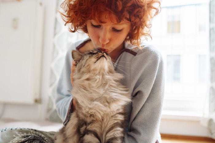 ちゅーする女性と猫