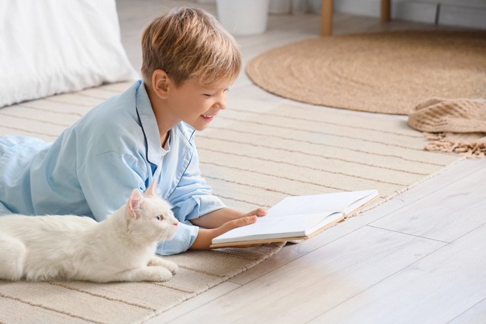 本を前にした猫と少年
