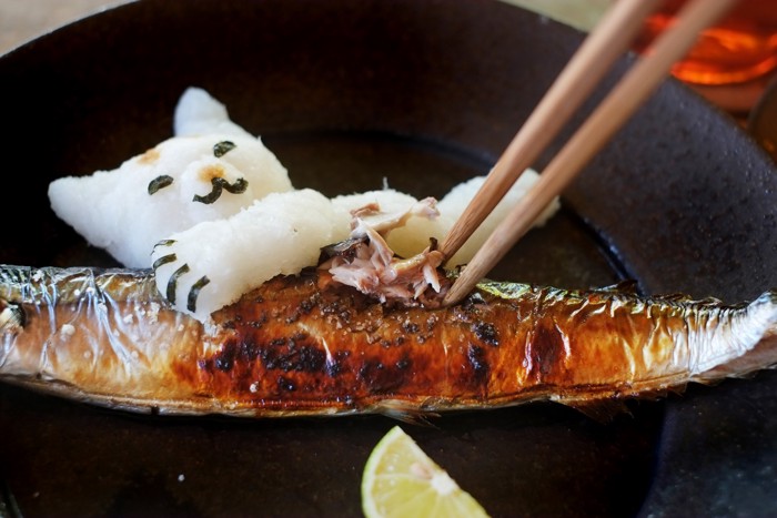 大根おろしで作った猫が添えられたさんまをほぐしている様子