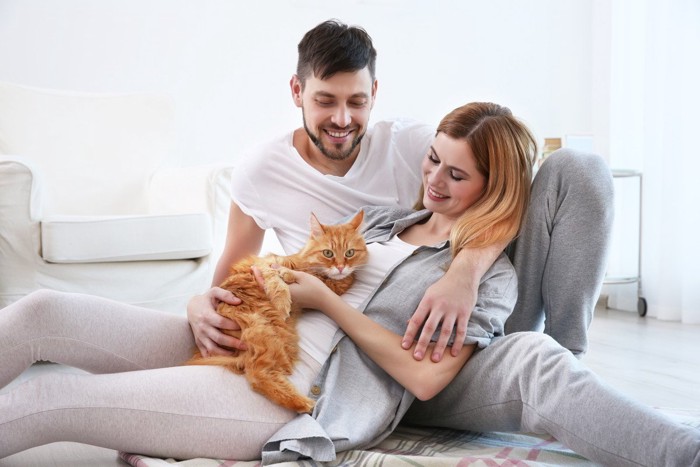 猫を抱いてくつろぐカップル