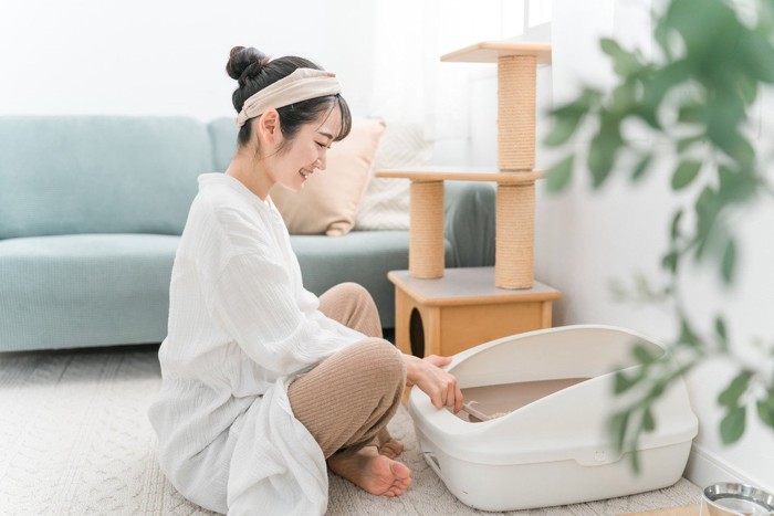 猫トイレの掃除をしている女性