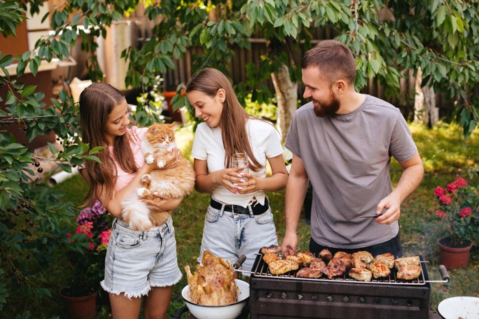 BBQしている男女と猫