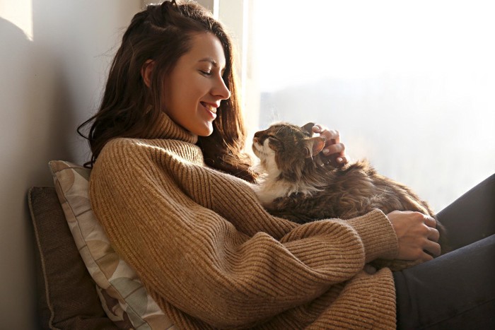 女性と膝に乗る猫