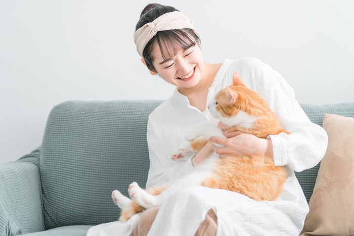 猫を膝に乗せて抱く女性