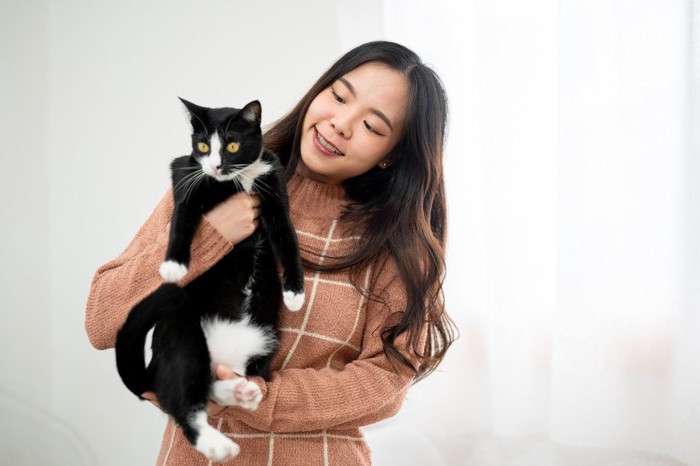 アジア人学生に抱かれる白黒猫