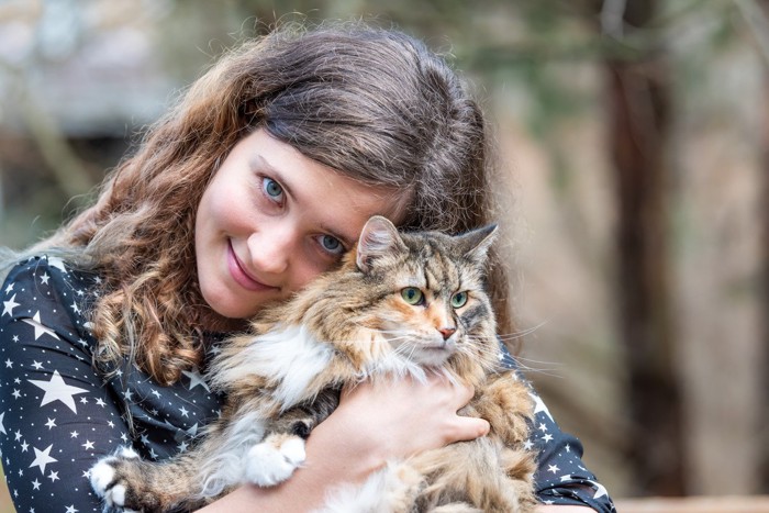 女性に抱かれている猫